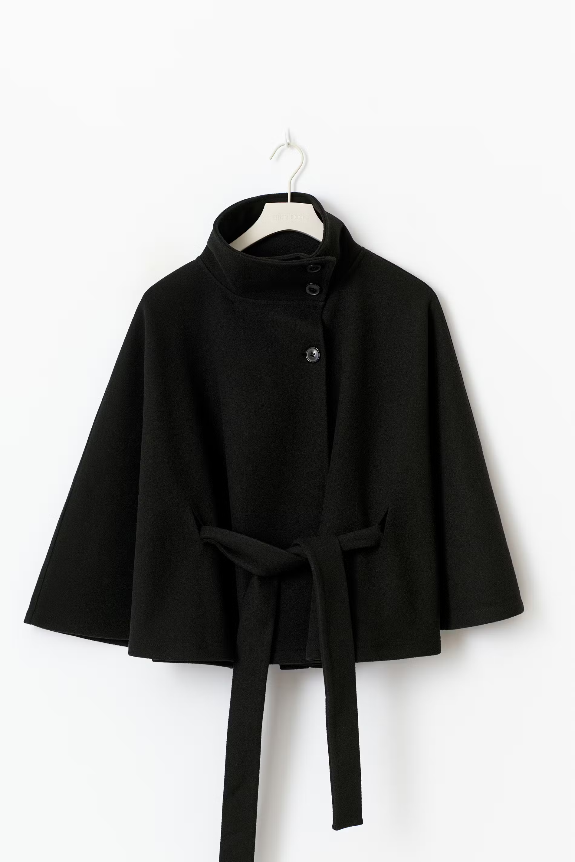 Zwarte cape jas met ceintuur en wijde pasvorm – volledige look